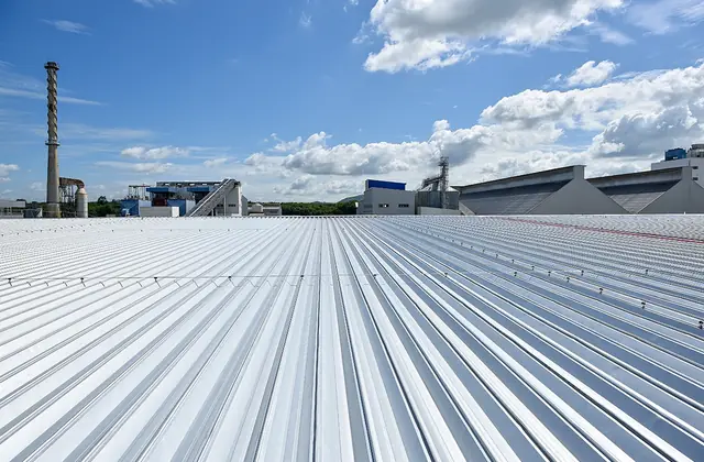Long metal-panel roof of a commercial building under a blue sky